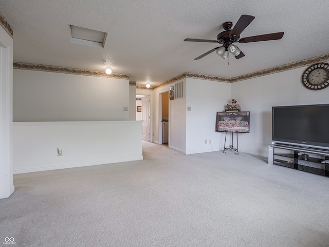 unfurnished living room featuring ceiling fan, a textured ceiling, and light colored carpet