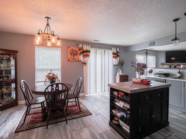 dining space featuring a textured ceiling, a chandelier, and plenty of natural light