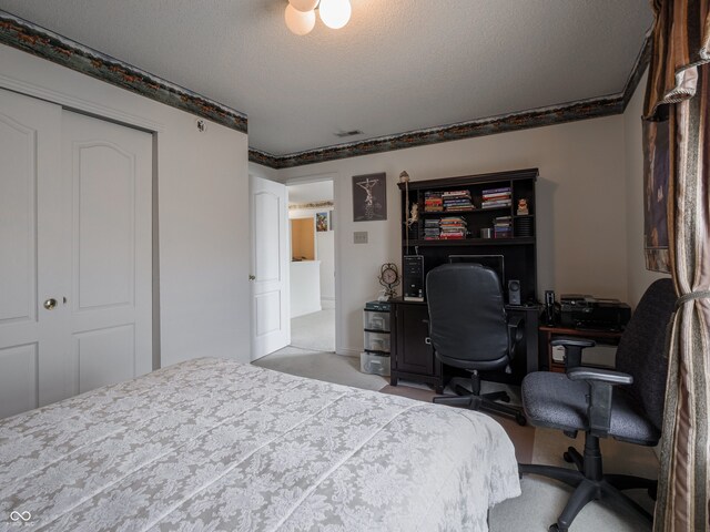 carpeted bedroom with a closet and a textured ceiling