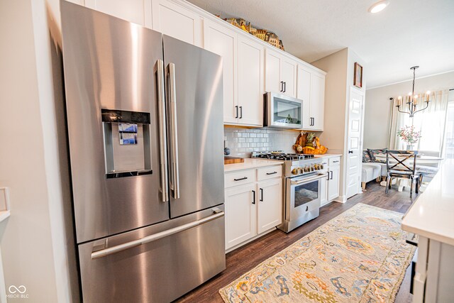 kitchen with white cabinetry, stainless steel appliances, and dark hardwood / wood-style floors