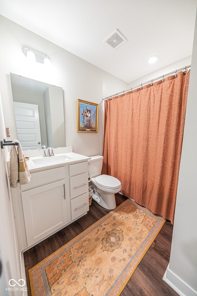 bathroom featuring toilet, hardwood / wood-style flooring, and vanity