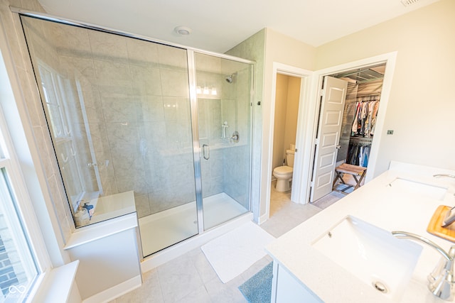 bathroom with vanity, tile patterned floors, toilet, and walk in shower