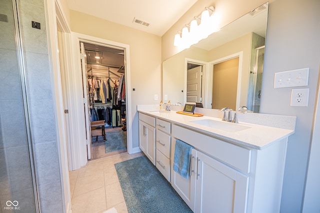 bathroom featuring a shower with door, tile patterned floors, and vanity