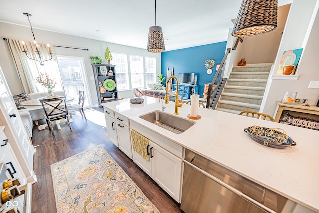 kitchen with sink, hanging light fixtures, stainless steel dishwasher, white cabinets, and dark hardwood / wood-style floors