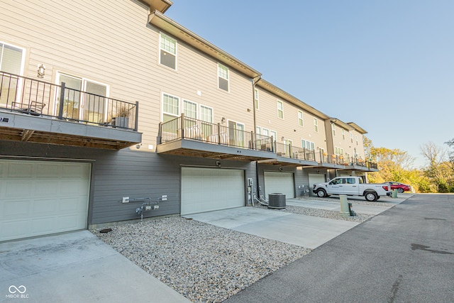 exterior space with a balcony, a garage, and central air condition unit