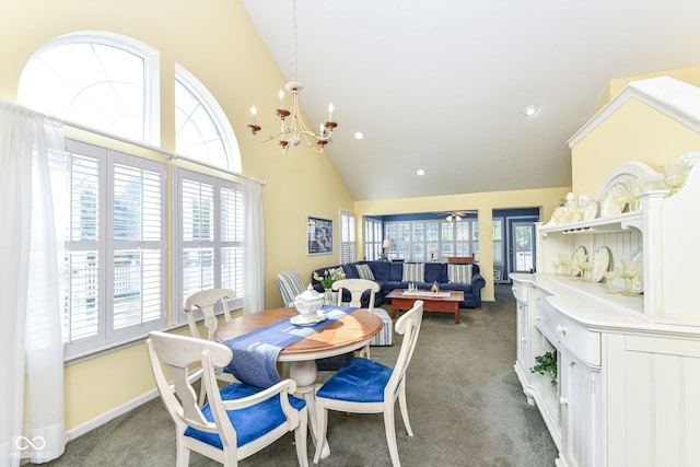 carpeted dining room with a chandelier and high vaulted ceiling