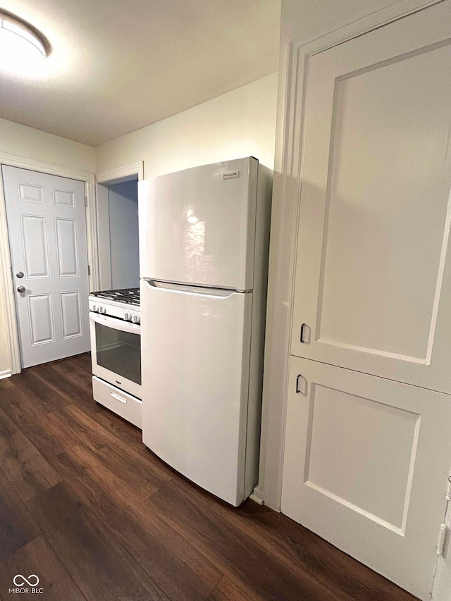 kitchen with dark hardwood / wood-style floors, white cabinets, and white appliances