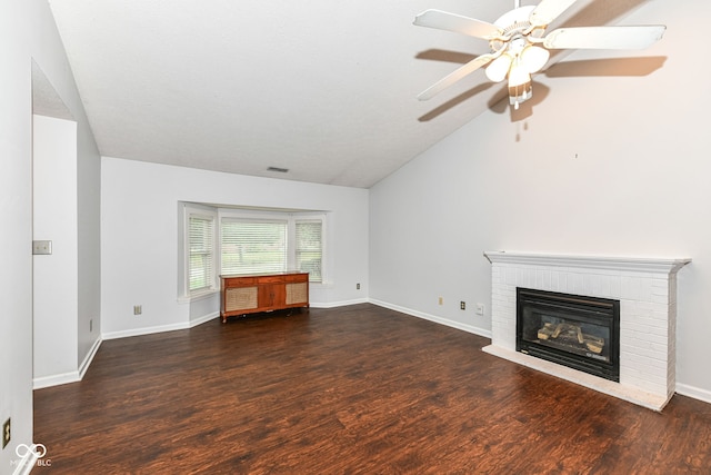 unfurnished living room featuring lofted ceiling, dark wood-type flooring, a brick fireplace, and ceiling fan