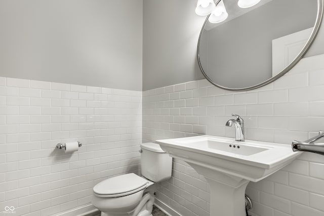 bathroom with toilet and tile walls