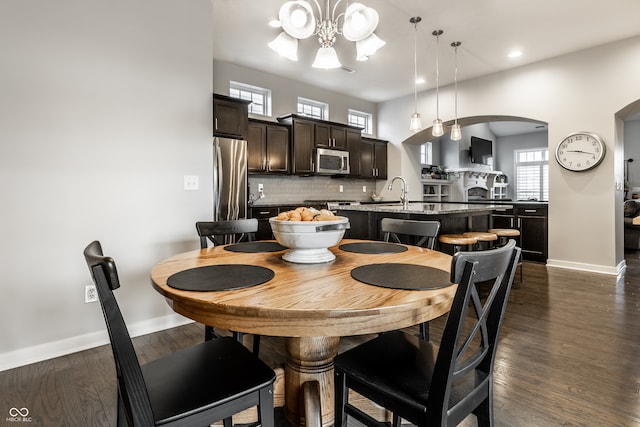 dining area with a chandelier, sink, and dark hardwood / wood-style flooring