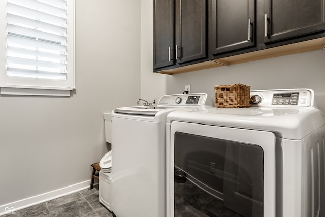 washroom featuring cabinets, independent washer and dryer, and dark tile patterned floors