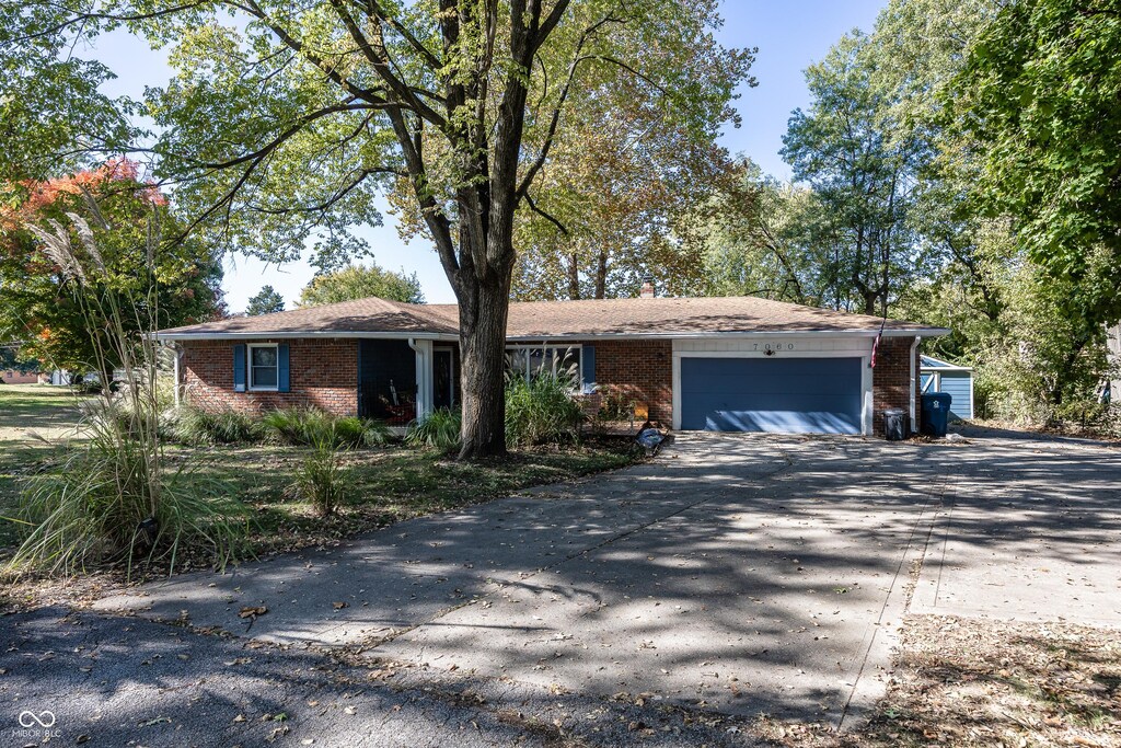 7060 S Meridian St, Indianapolis, IN 46217 - single story home featuring an attached garage, aphalt driveway, and brick siding