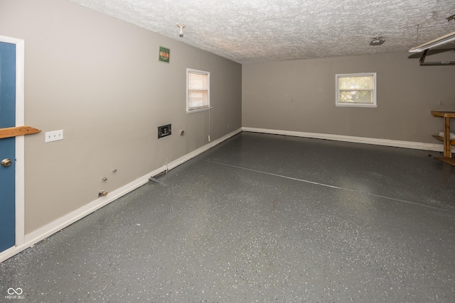 interior space featuring baseboards, a textured ceiling, and plenty of natural light
