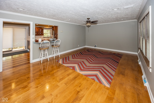 unfurnished room with crown molding, hardwood / wood-style flooring, and a textured ceiling