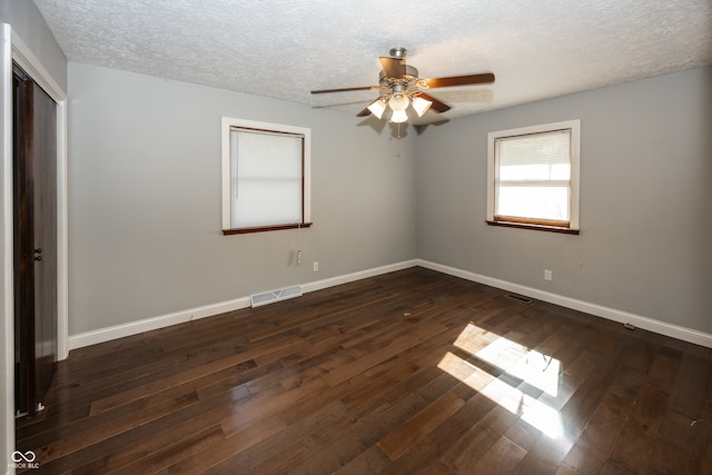 spare room with ceiling fan, a textured ceiling, and dark hardwood / wood-style flooring