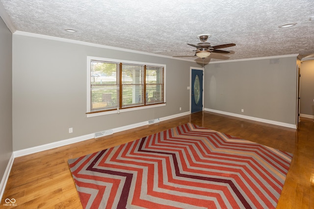 unfurnished room featuring visible vents, wood finished floors, a ceiling fan, and crown molding