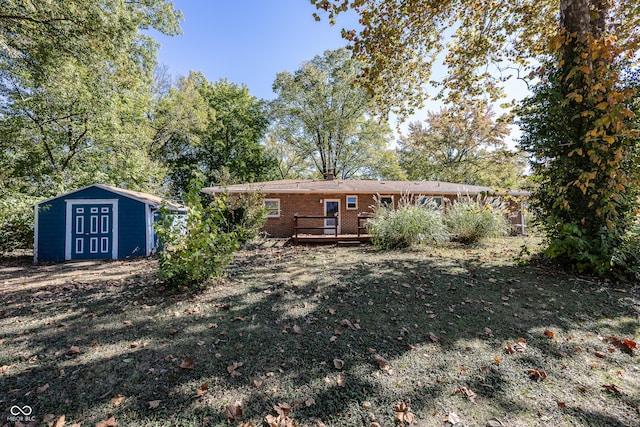 back of house with an outdoor structure, a chimney, a shed, brick siding, and a deck