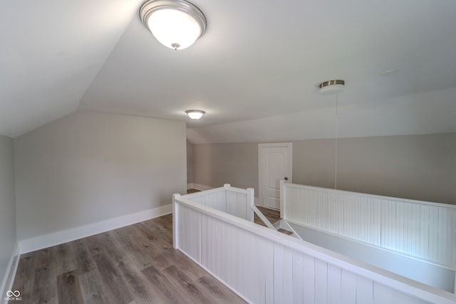 hallway featuring lofted ceiling and hardwood / wood-style floors