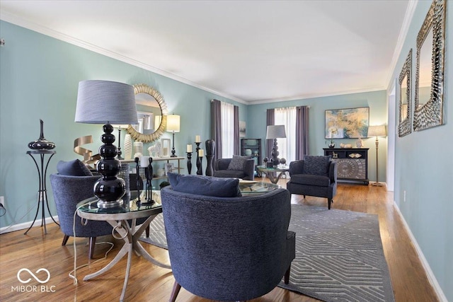 living room featuring crown molding, baseboards, and wood finished floors