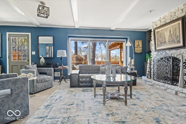 living room with beam ceiling, crown molding, carpet, and a fireplace with raised hearth