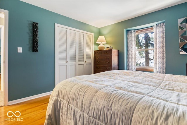 bedroom featuring a closet, baseboards, and wood finished floors