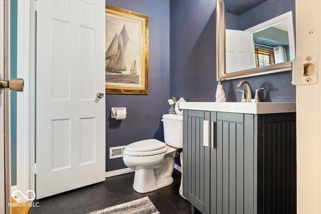 bathroom with toilet, vanity, and baseboards