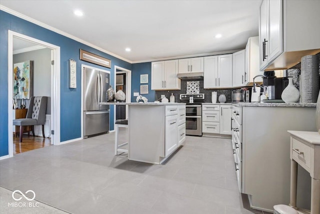 kitchen featuring white cabinetry, under cabinet range hood, light countertops, and appliances with stainless steel finishes