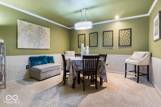 dining room with wainscoting, carpet, and ornamental molding