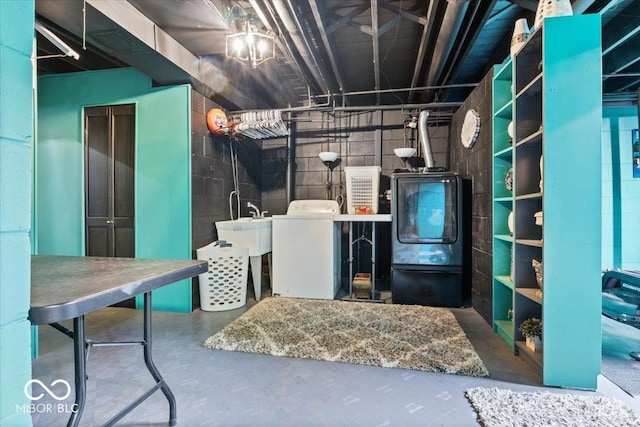 unfinished basement featuring a sink, washer / dryer, and concrete block wall