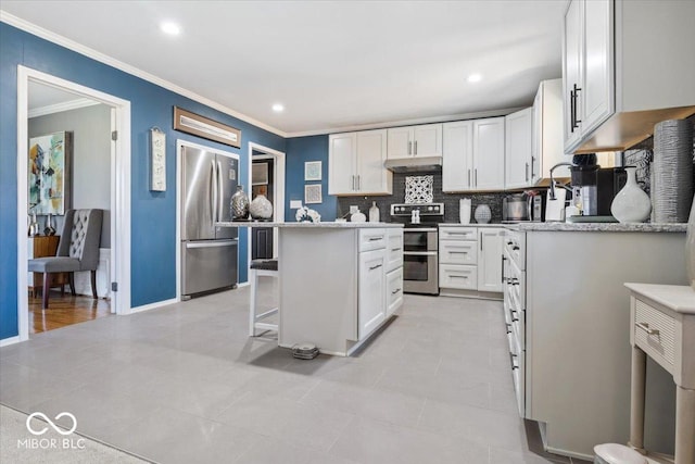 kitchen with white cabinets, a kitchen island, under cabinet range hood, and stainless steel appliances