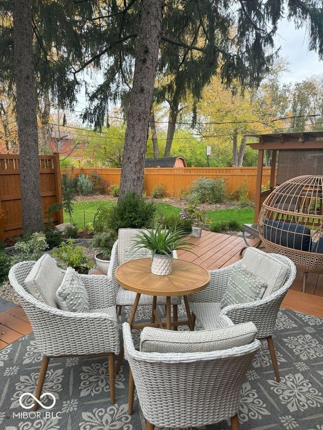 view of patio with outdoor dining area, a fenced backyard, and a wooden deck