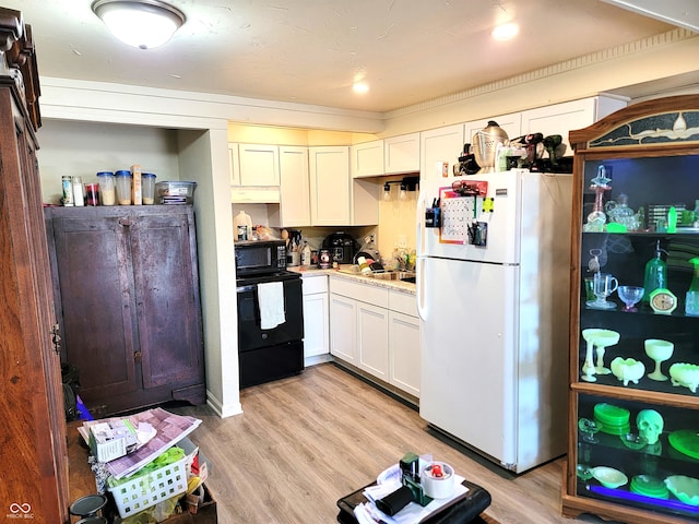 kitchen featuring white cabinetry, black appliances, and light wood-type flooring