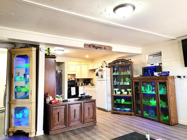 kitchen featuring light hardwood / wood-style floors, oven, white fridge, and a wall mounted AC