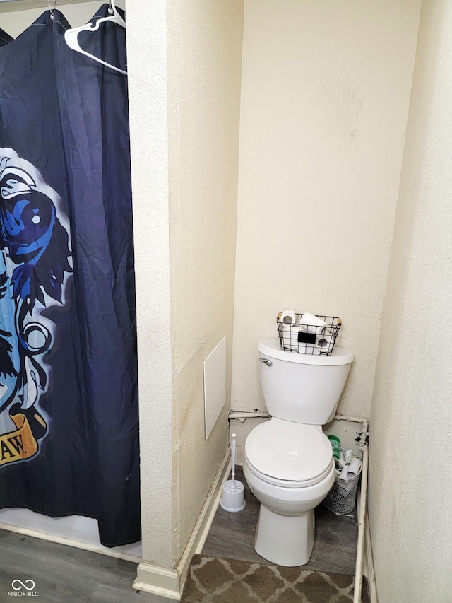 bathroom with toilet, hardwood / wood-style flooring, and a shower with shower curtain