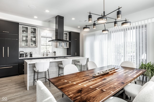 dining area featuring sink, a chandelier, and light wood-type flooring