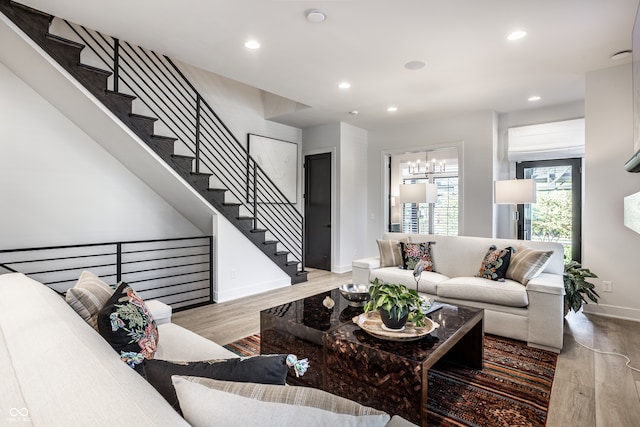 living room featuring a notable chandelier and light wood-type flooring