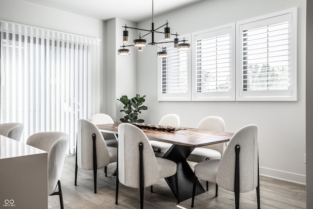 dining space featuring light hardwood / wood-style flooring and a chandelier