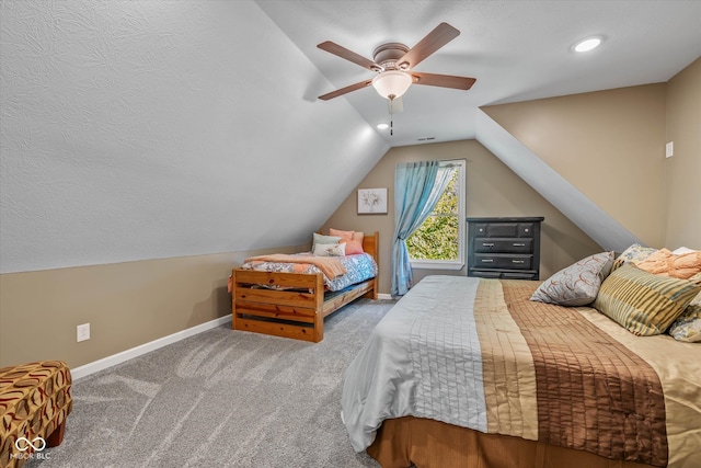 carpeted bedroom with ceiling fan and vaulted ceiling