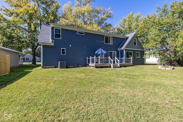 rear view of house featuring cooling unit, a deck, and a lawn