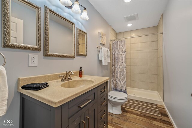 bathroom with vanity, curtained shower, wood-type flooring, and toilet