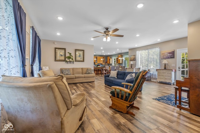 living room with light hardwood / wood-style floors and ceiling fan