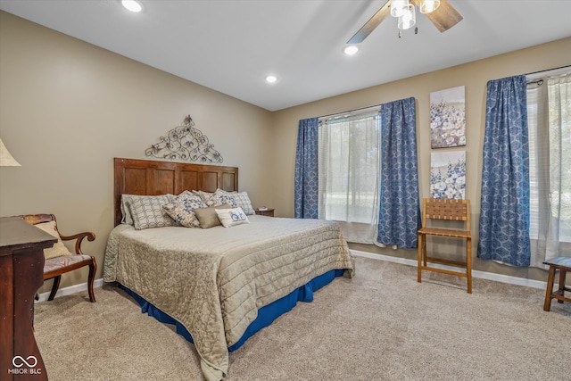 carpeted bedroom featuring multiple windows and ceiling fan