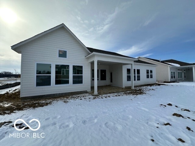 view of snow covered rear of property