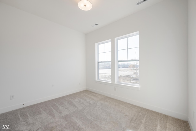 unfurnished room featuring light carpet, visible vents, and baseboards