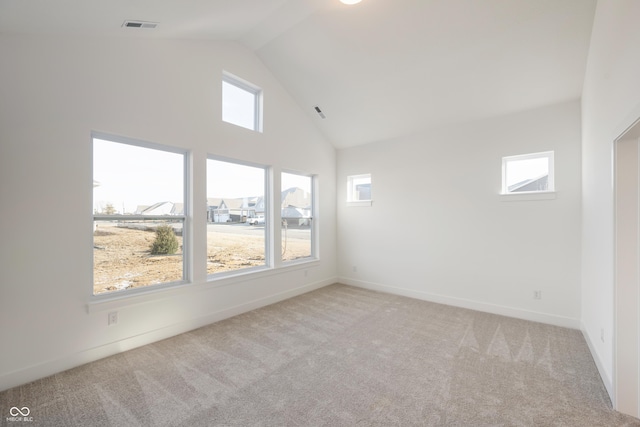 empty room with baseboards, light colored carpet, high vaulted ceiling, and visible vents