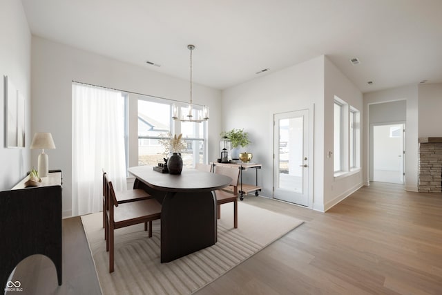 dining room with a chandelier, visible vents, and light wood-style flooring