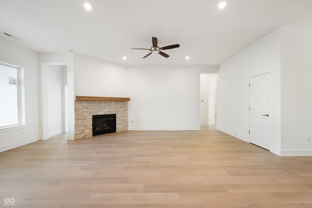 unfurnished living room featuring light wood-type flooring, recessed lighting, a stone fireplace, and visible vents