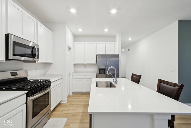 10008 Sundley Dr, Indianapolis, IN 46239 - kitchen featuring light countertops, stainless steel appliances, a sink, light wood-style floors, and an island with sink