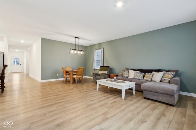 10008 Sundley Dr, Indianapolis, IN 46239 - living room featuring baseboards, light wood-type flooring, and a notable chandelier