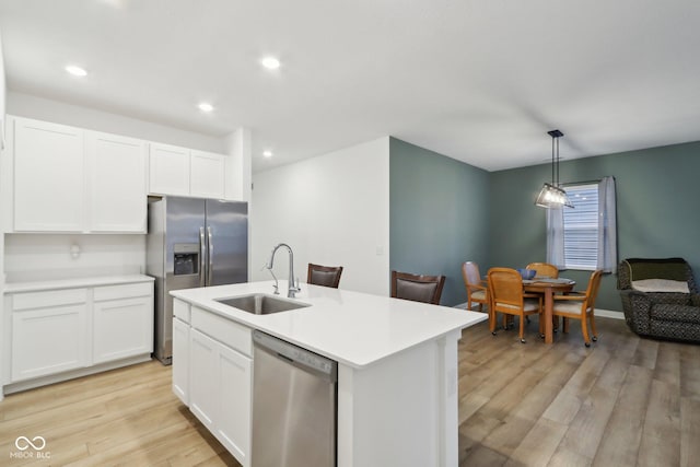 10008 Sundley Dr, Indianapolis, IN 46239 - kitchen featuring light countertops, a sink, white cabinetry, appliances with stainless steel finishes, and light wood-style floors